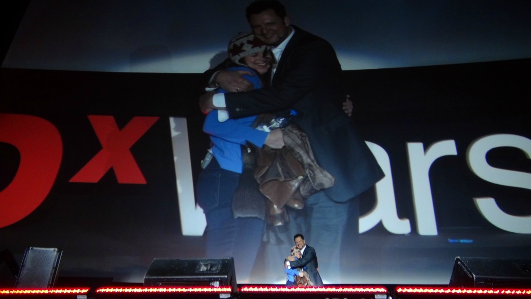 Erica Hargreave and Ralph Talmount hugging over a TEDxWarsaw talk.